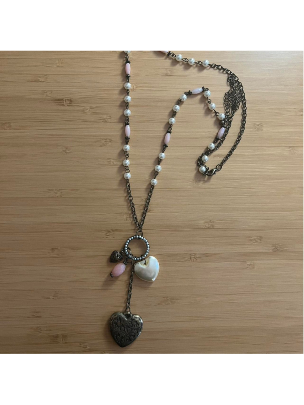 Vintage-looking bronze necklace with heart charms and pink and white beads